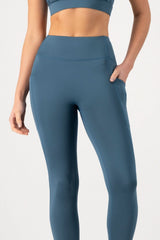 Person wearing blue leggings on a light gray background