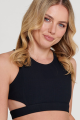 Woman wearing a black sports bra against a plain background