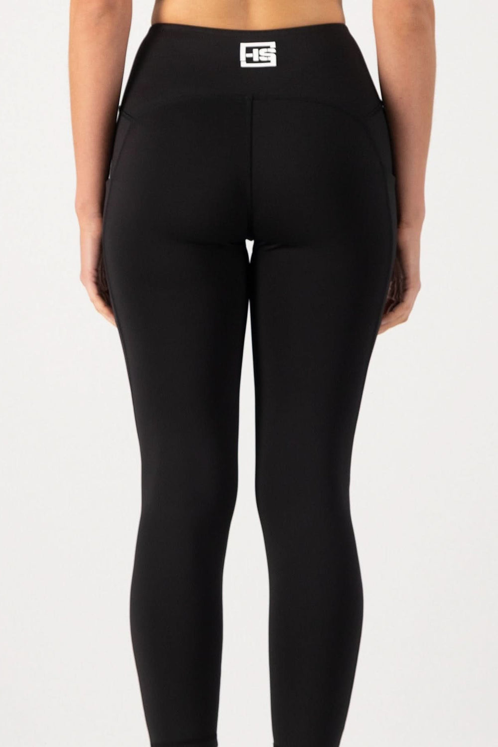 Black leggings with a logo on the waistband against a white background