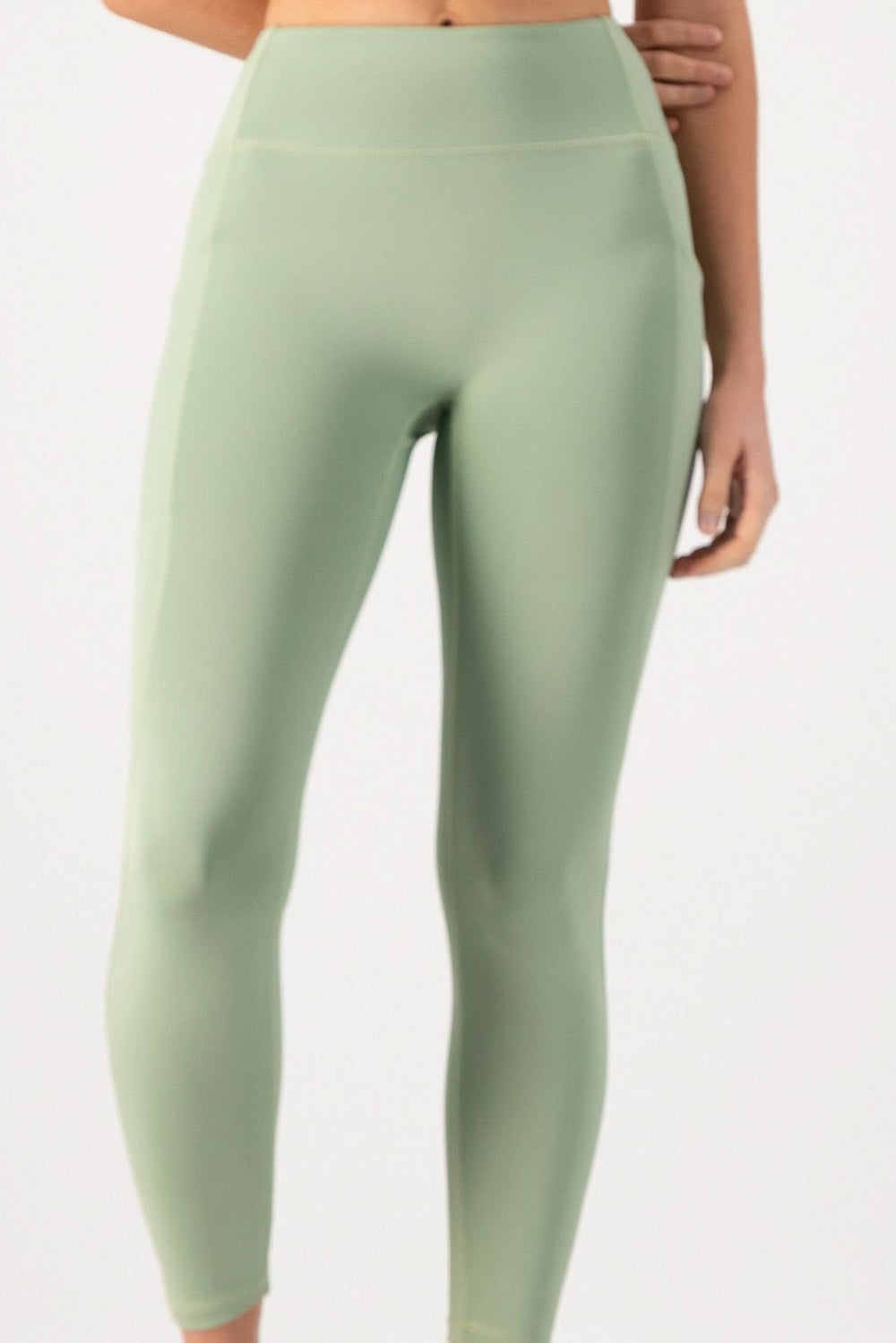 Green leggings worn by a person on a white background