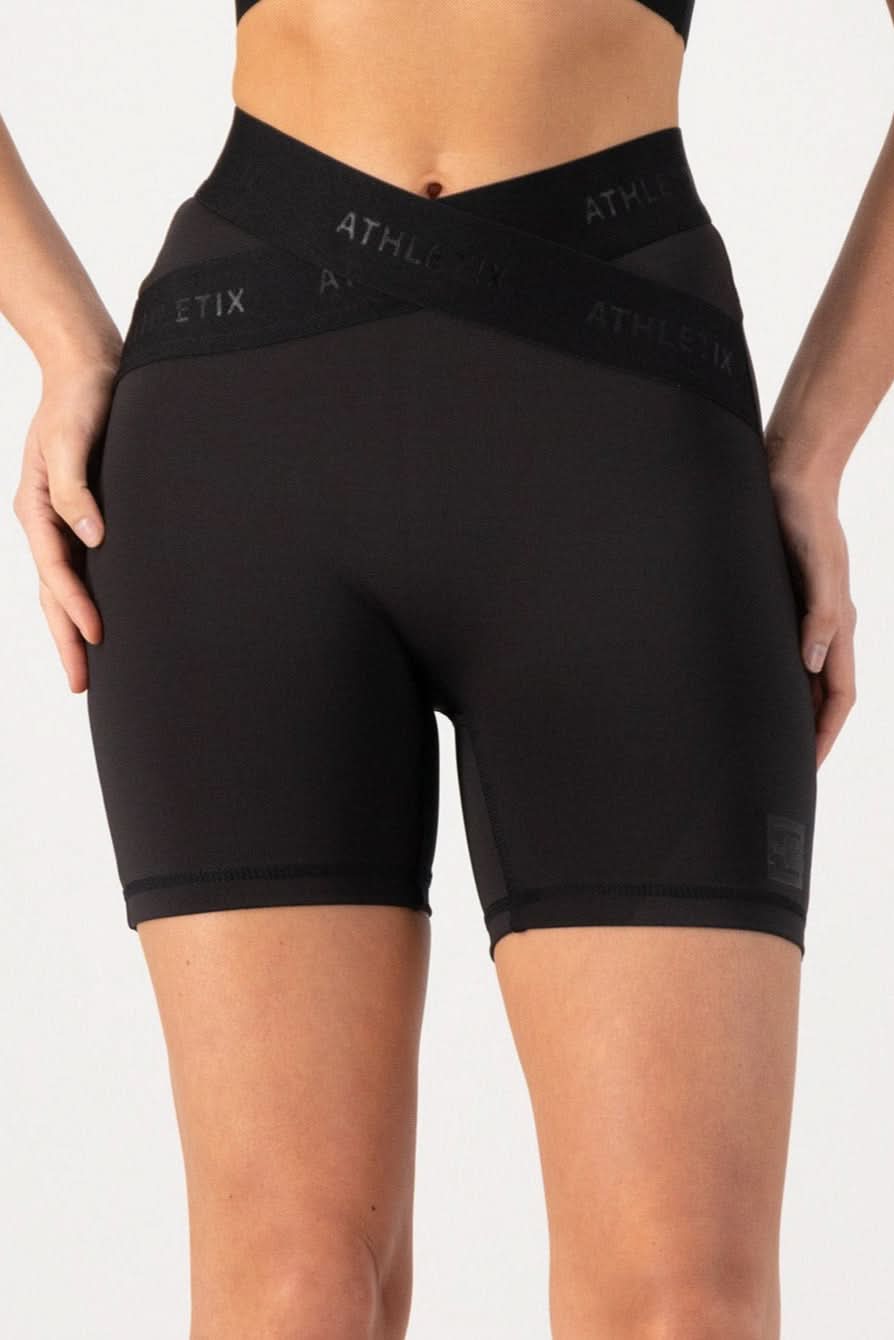 Athletic training shorts with an elasticated waistband and cross-over design, featuring a predominantly black color with the brand logo 'ATHLETIC' visible on the waistband.